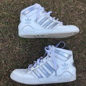 White and silver Adidas high top shoes.